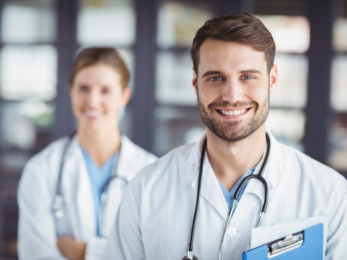 Portrait of happy doctors standing in hospital